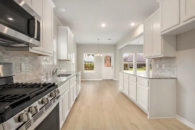 a kitchen with stainless steel appliances a sink stove and cabinets
