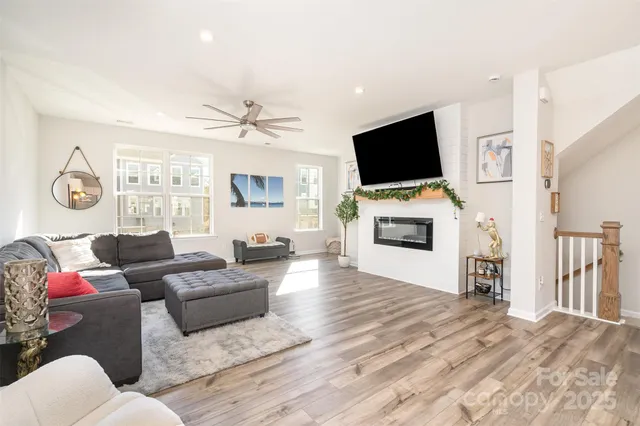 a living room with furniture a flat screen tv and a fireplace