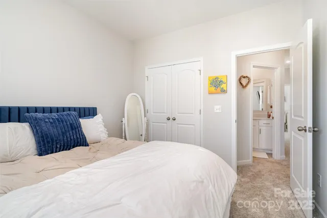 a bedroom with a bed and a flat tv screen on dresser