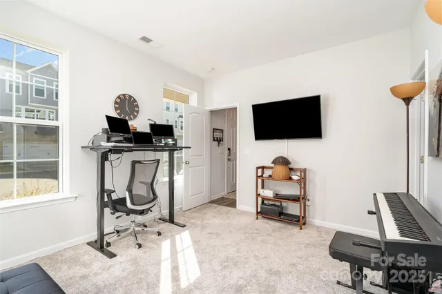 a view of a workspace with furniture and a flat screen tv