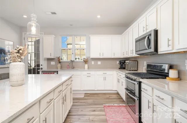 a kitchen with stainless steel appliances granite countertop a stove sink and cabinets