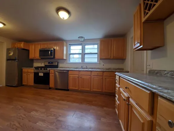 a kitchen with granite countertop a sink cabinets and wooden floor