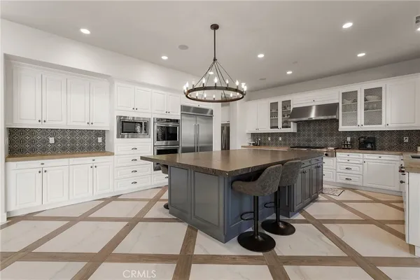 a dining room with stainless steel appliances granite countertop furniture and a window