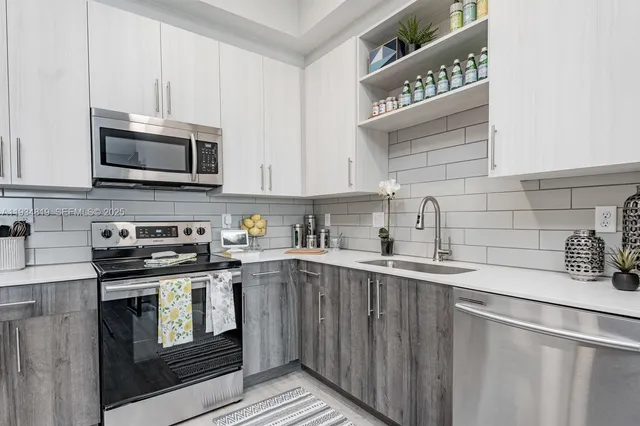 a kitchen with granite countertop a sink a stove and cabinets