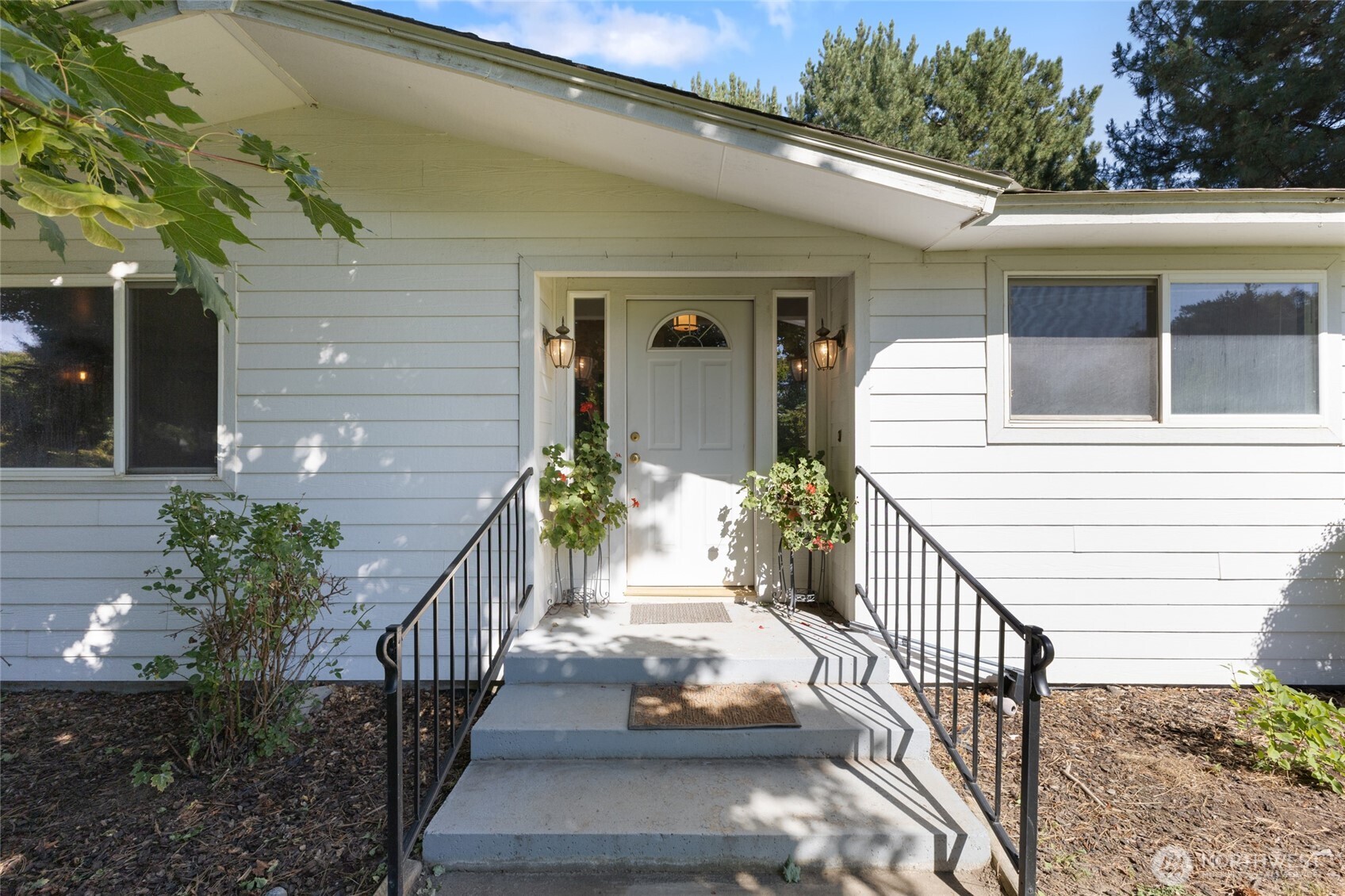 2299 Admiral Road Northeast Moses Lake, WA 98837 - Photo 4 of 40 a view of a house with large windows and flower plants