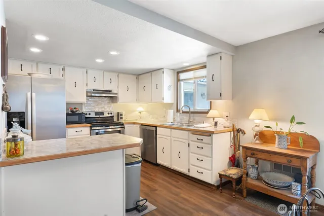 a kitchen with stainless steel appliances a stove a sink cabinets and a refrigerator