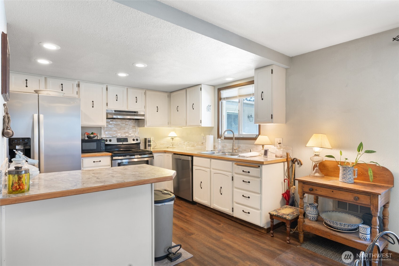 2299 Admiral Road Northeast Moses Lake, WA 98837 - Photo 10 of 40 a kitchen with stainless steel appliances a stove a sink cabinets and a refrigerator