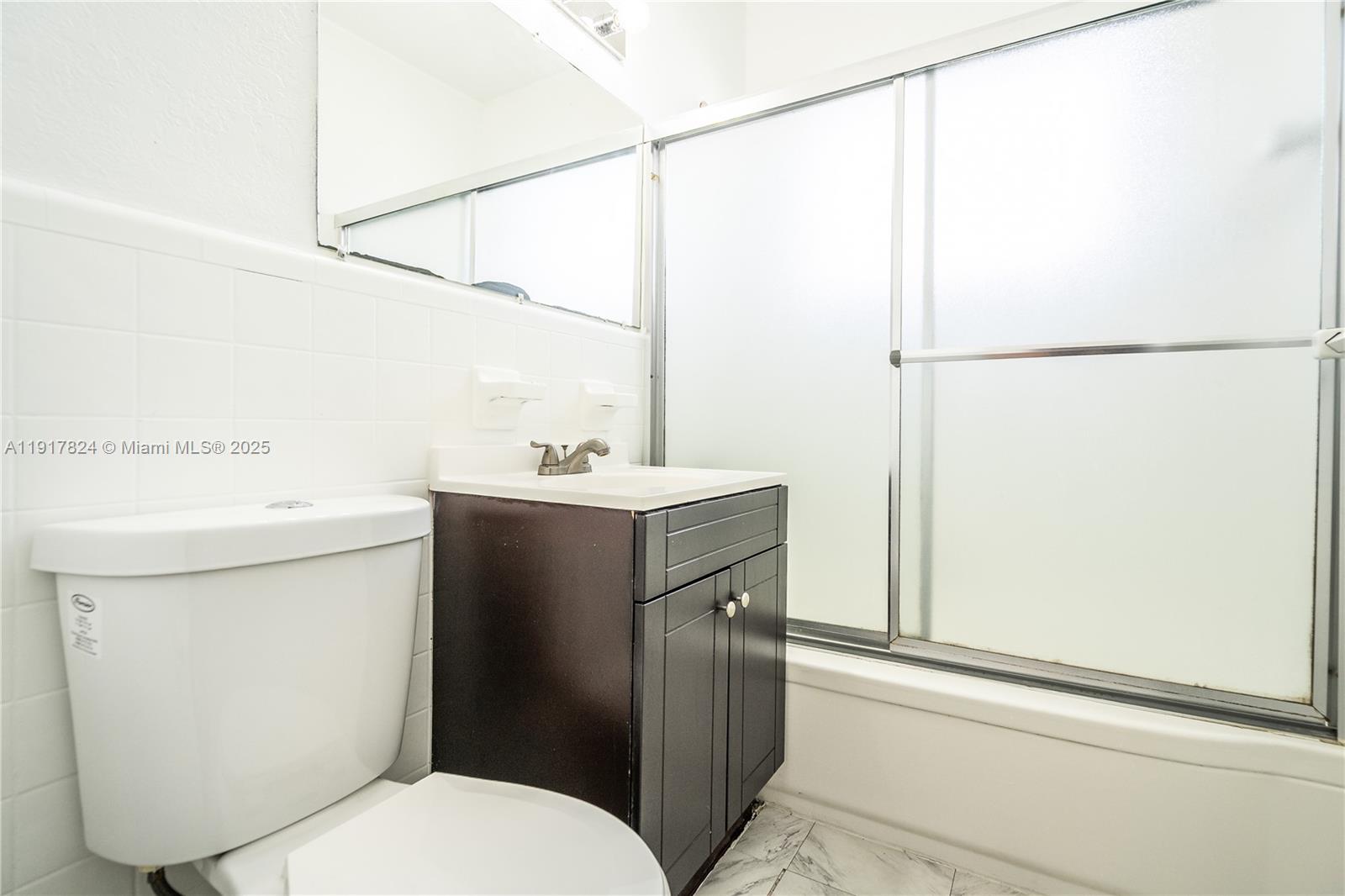 330 84th Street, Unit 12 Miami Beach, FL 33141 - Photo 18 of 20 a bathroom with a sink toilet and mirror