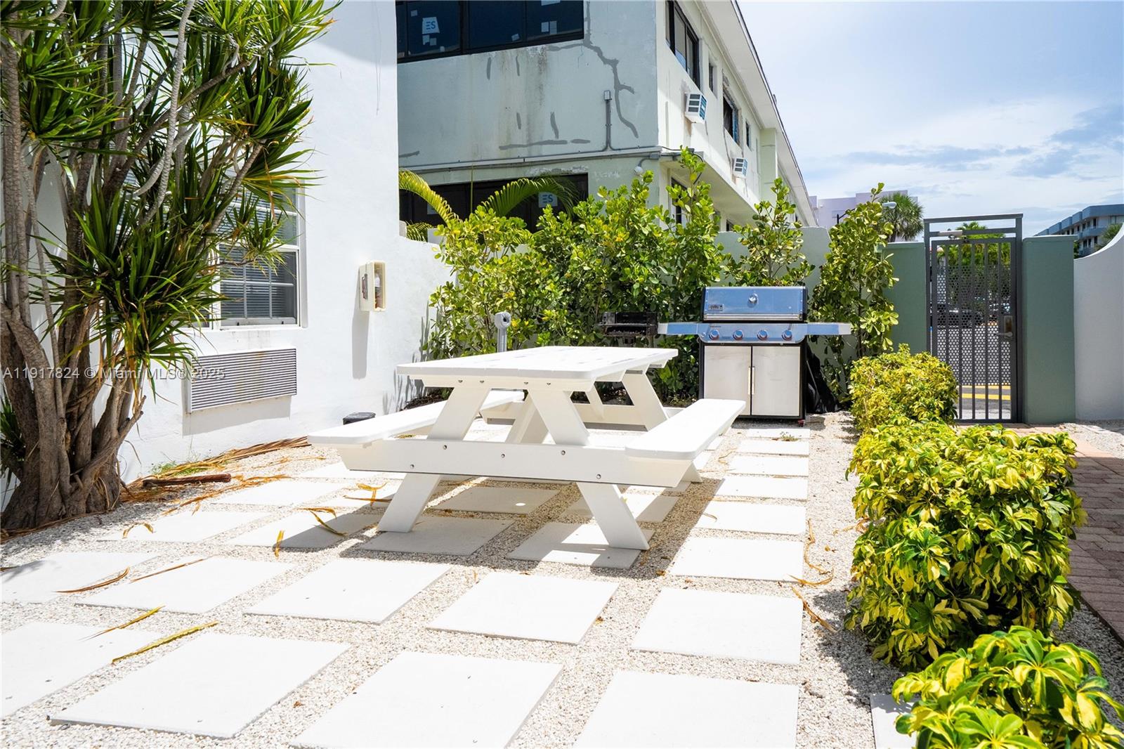 330 84th Street, Unit 12 Miami Beach, FL 33141 - Photo 19 of 20 a view of a patio with table and chairs and potted plants