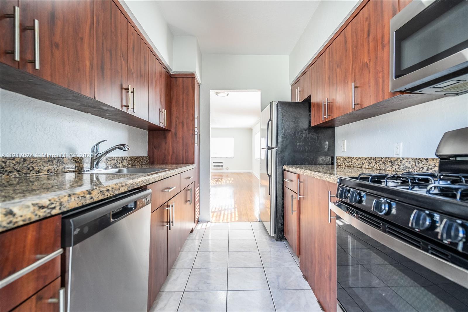 330 84th Street, Unit 12 Miami Beach, FL 33141 - Photo 8 of 20 a kitchen with stainless steel appliances granite countertop a refrigerator a stove and a sink