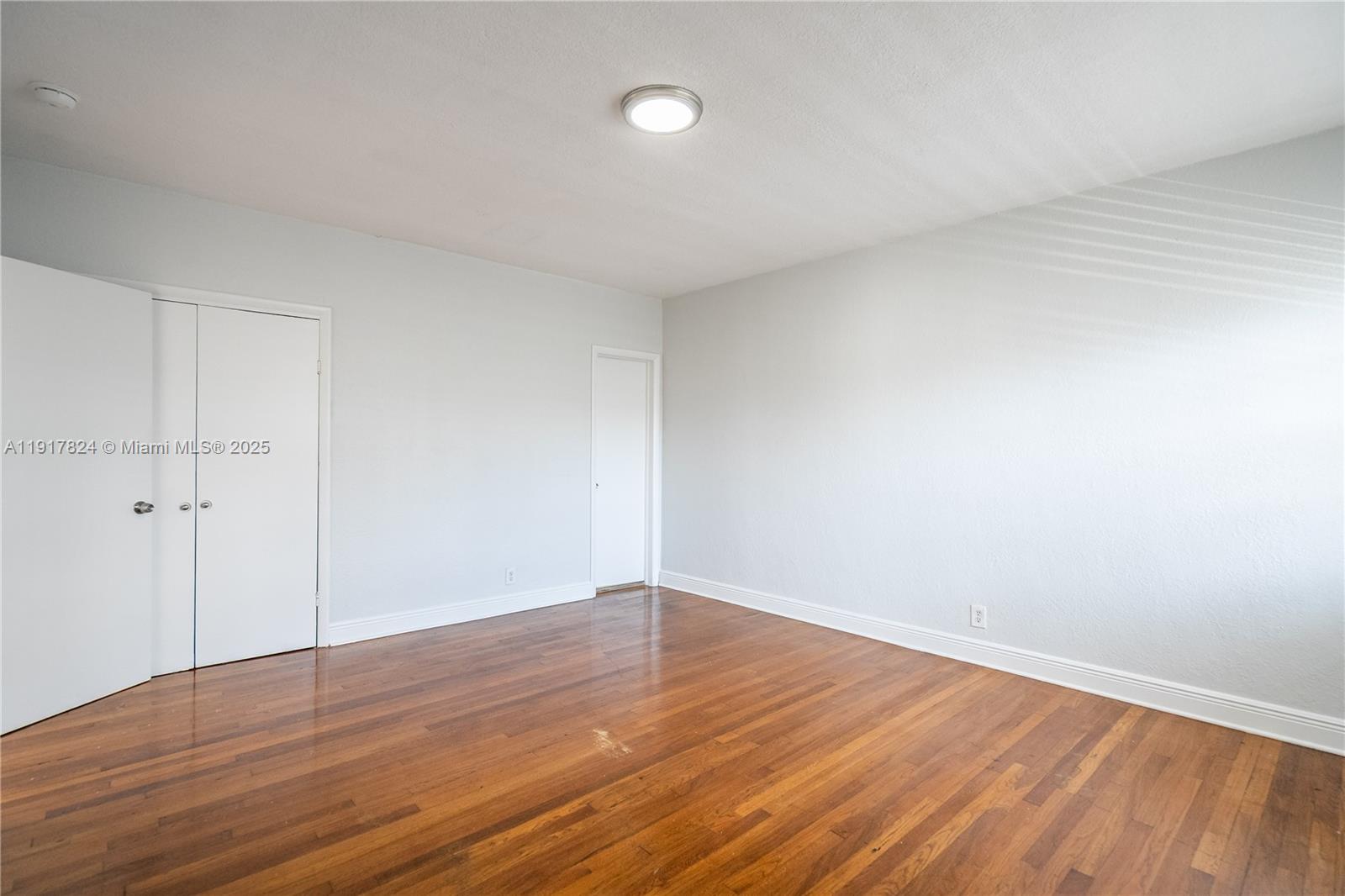 330 84th Street, Unit 12 Miami Beach, FL 33141 - Photo 10 of 20 a view of an empty room with wooden floor
