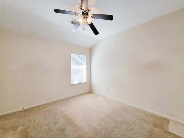 an empty room with a window and a fan