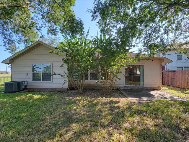 a view of a house with a yard and a large tree