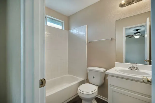 a bathroom with a granite countertop toilet a sink and a bathtub