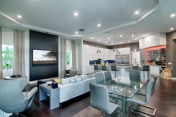 a large kitchen with stainless steel appliances a stove a sink dishwasher and a dining table with wooden floor