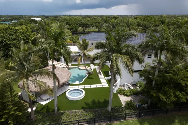 an aerial view of a residential houses with outdoor space and swimming pool