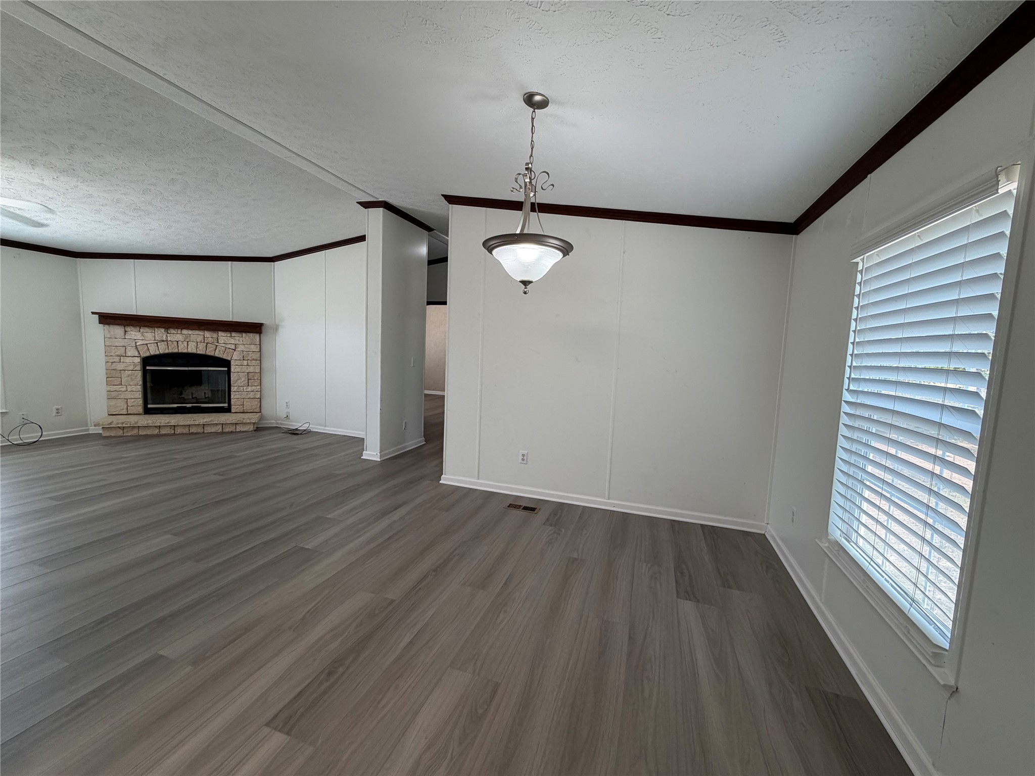 161 Phelan Road Bastrop, TX 78602 - Photo 11 of 18 A stone fireplace anchors the open-concept layout defined by wood-look flooring and clean trim work.