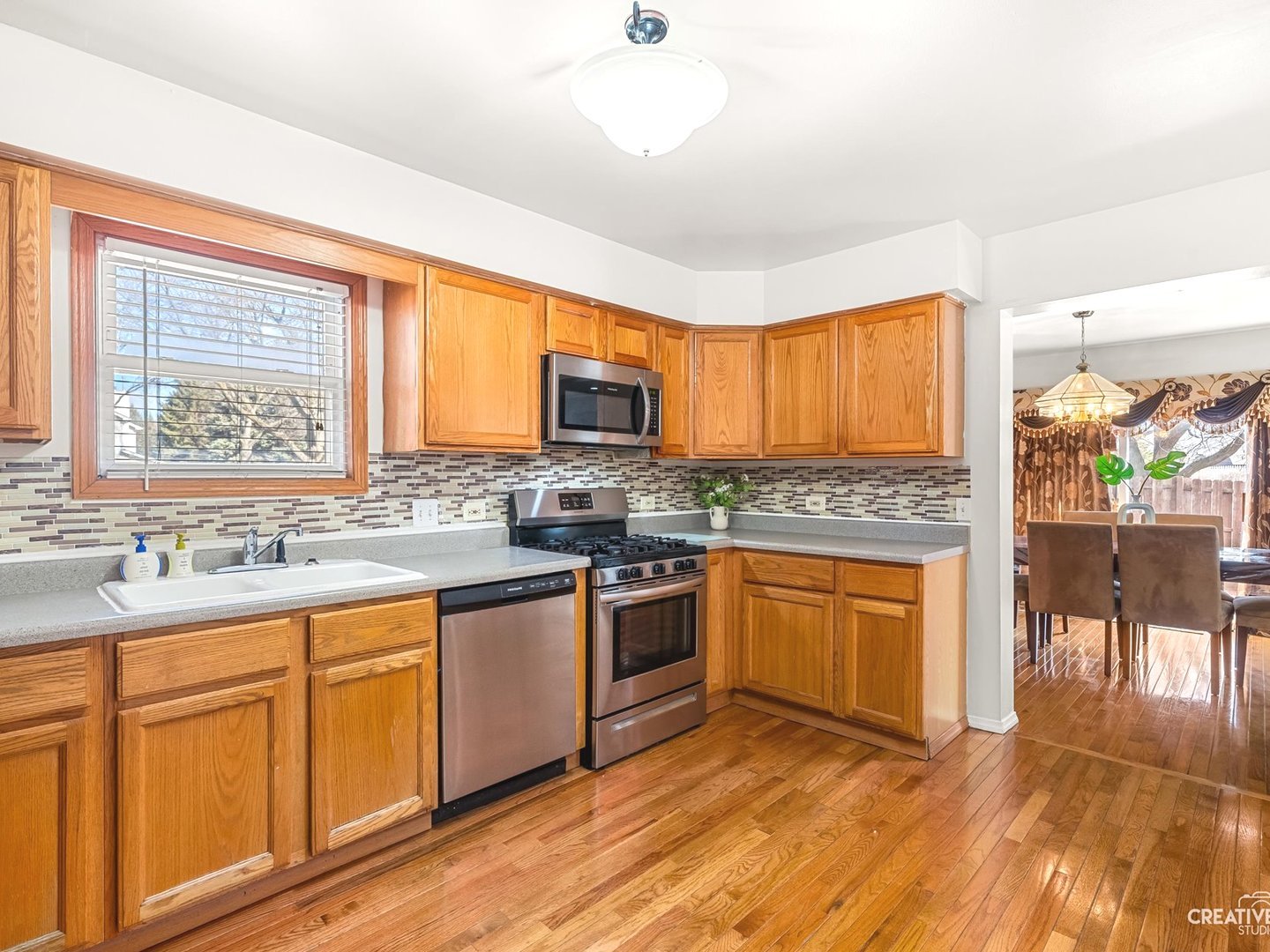 301 Inner Cir Drive Bolingbrook, IL 60490 - Photo 8 of 20 a kitchen with stainless steel appliances granite countertop wooden cabinets a sink a stove a dining table and chairs