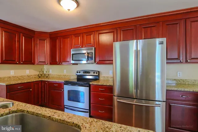 a kitchen with stainless steel appliances granite countertop a refrigerator and a sink
