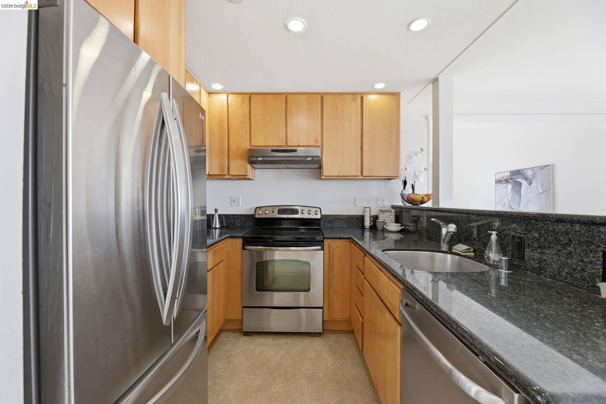 2634 Virginia Street, Unit 33 Berkeley, CA 94709 - Photo 12 of 31 a kitchen with stainless steel appliances granite countertop a sink a stove a refrigerator and cabinets