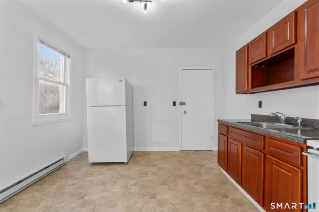 a kitchen with stainless steel appliances granite countertop a refrigerator and a sink