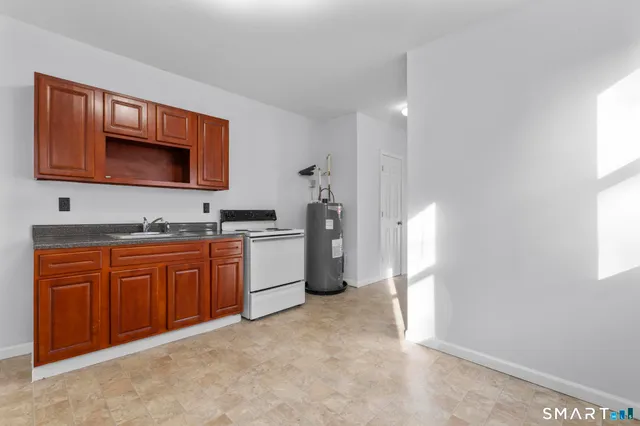 a kitchen with granite countertop a refrigerator and a stove top oven