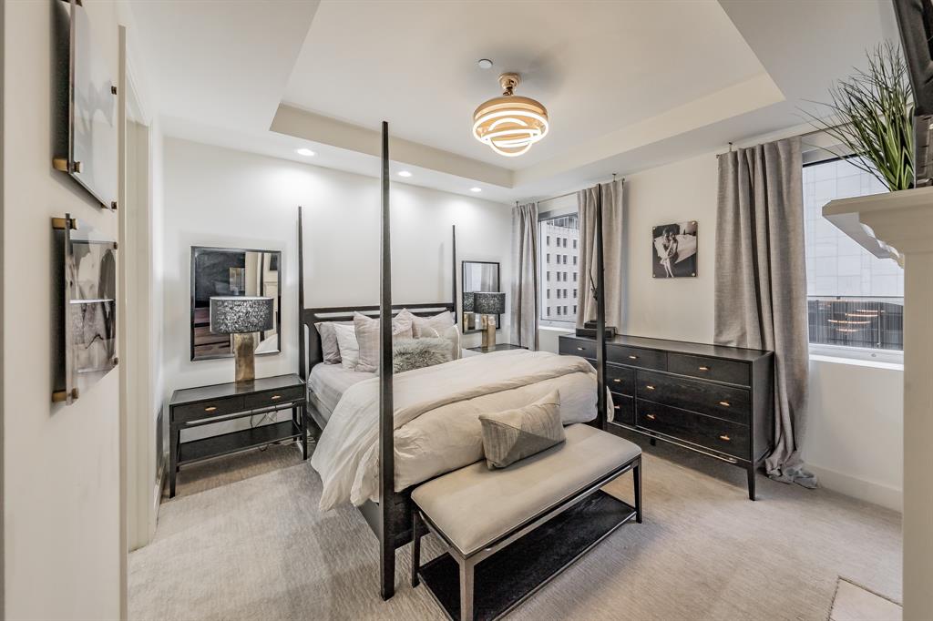 1505 Elm Street, Unit 404 Dallas, TX 75201 - Photo 16 of 40 a bedroom with furniture and a lamp