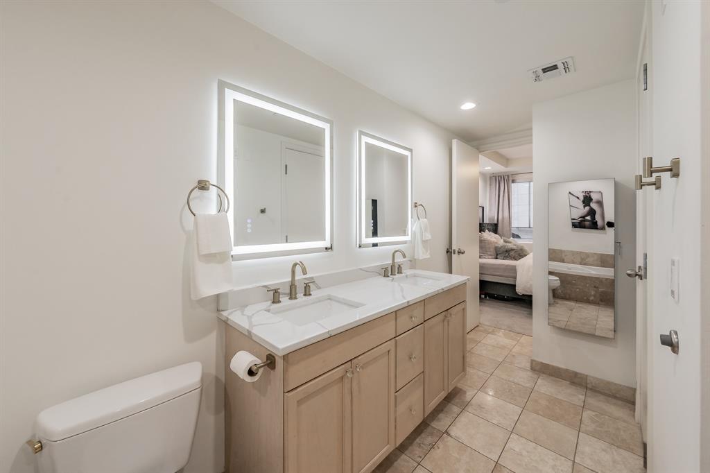 1505 Elm Street, Unit 404 Dallas, TX 75201 - Photo 21 of 40 a spacious bathroom with a sink a toilet and a mirror