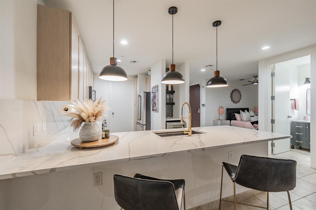 1505 Elm Street, Unit 404 Dallas, TX 75201 - Photo 6 of 40 a dining table chairs and a chandelier