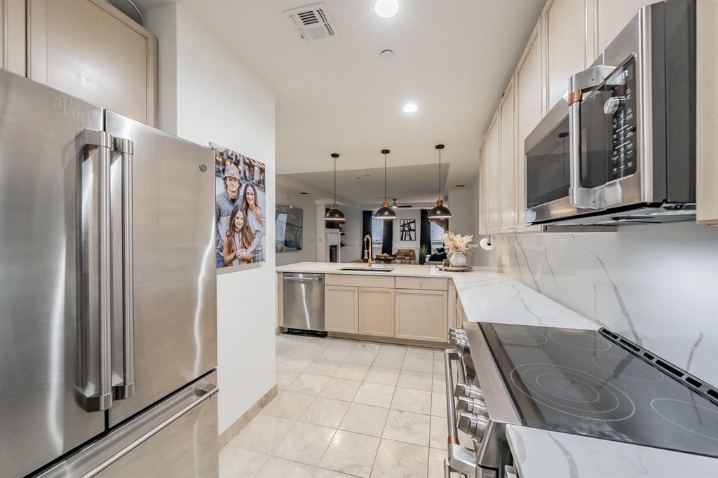 1505 Elm Street, Unit 404 Dallas, TX 75201 - Photo 9 of 40 a kitchen with stainless steel appliances granite countertop a refrigerator and a sink