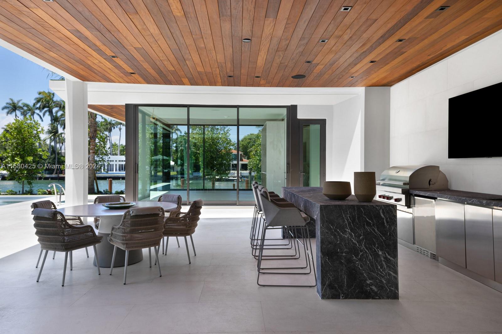 2700 Sunset Drive Miami Beach, FL 33140 - Photo 9 of 40 a living room with furniture a flat screen tv and floor to ceiling window