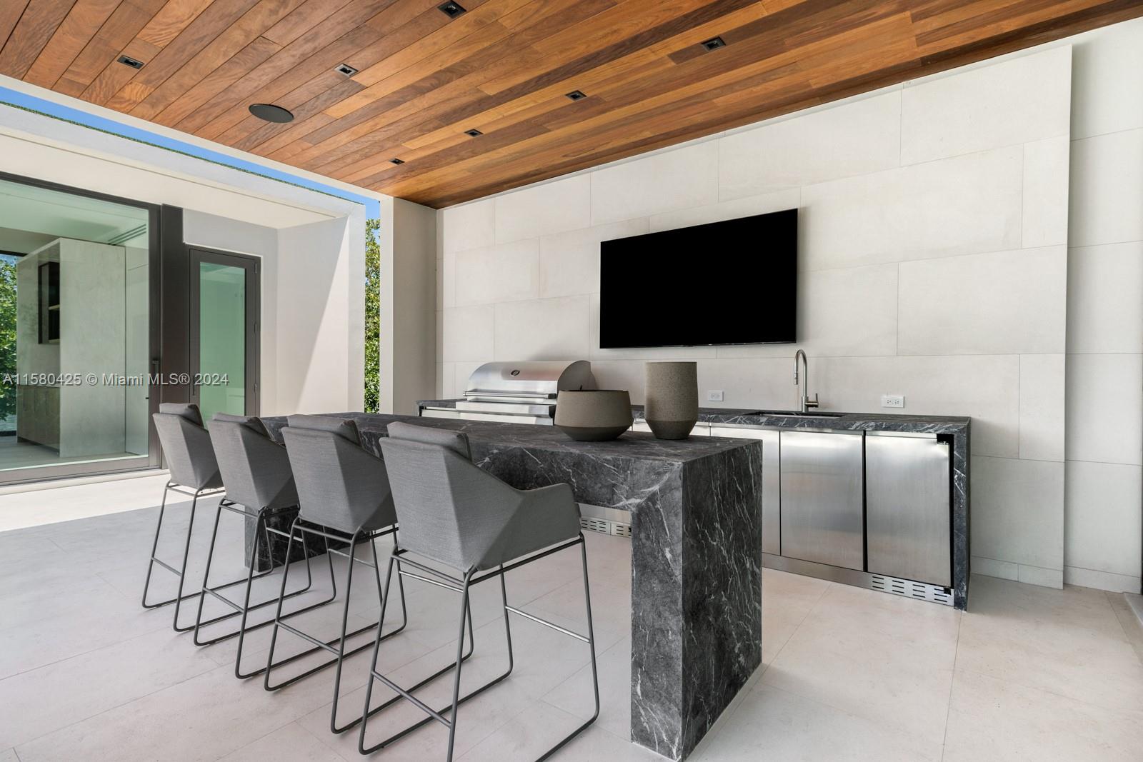 2700 Sunset Drive Miami Beach, FL 33140 - Photo 10 of 40 a dining room with furniture and a flat screen tv