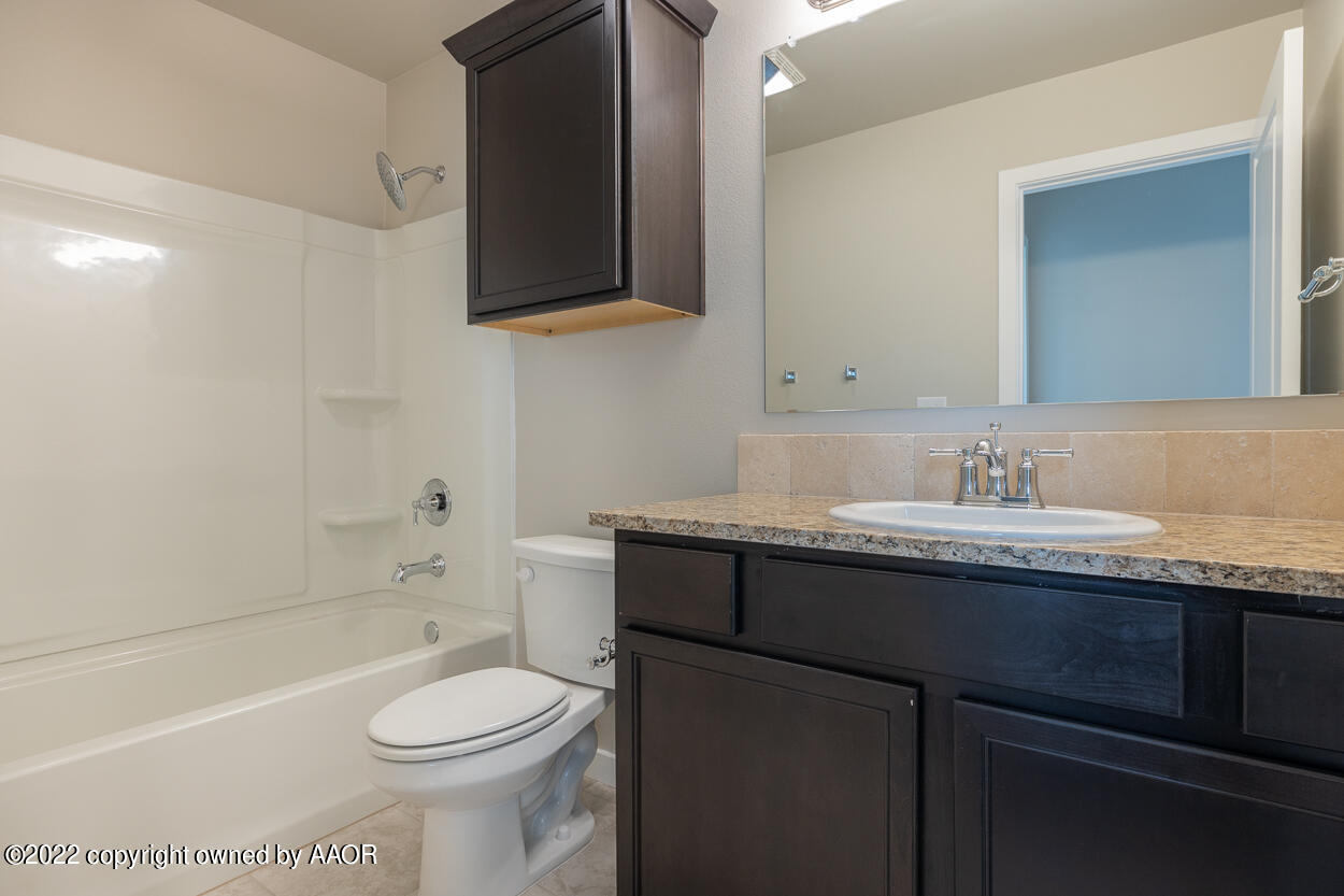 2600 Daybreak Lane Amarillo, TX 79124 - Photo 34 of 36 a bathroom with a granite countertop toilet sink and mirror