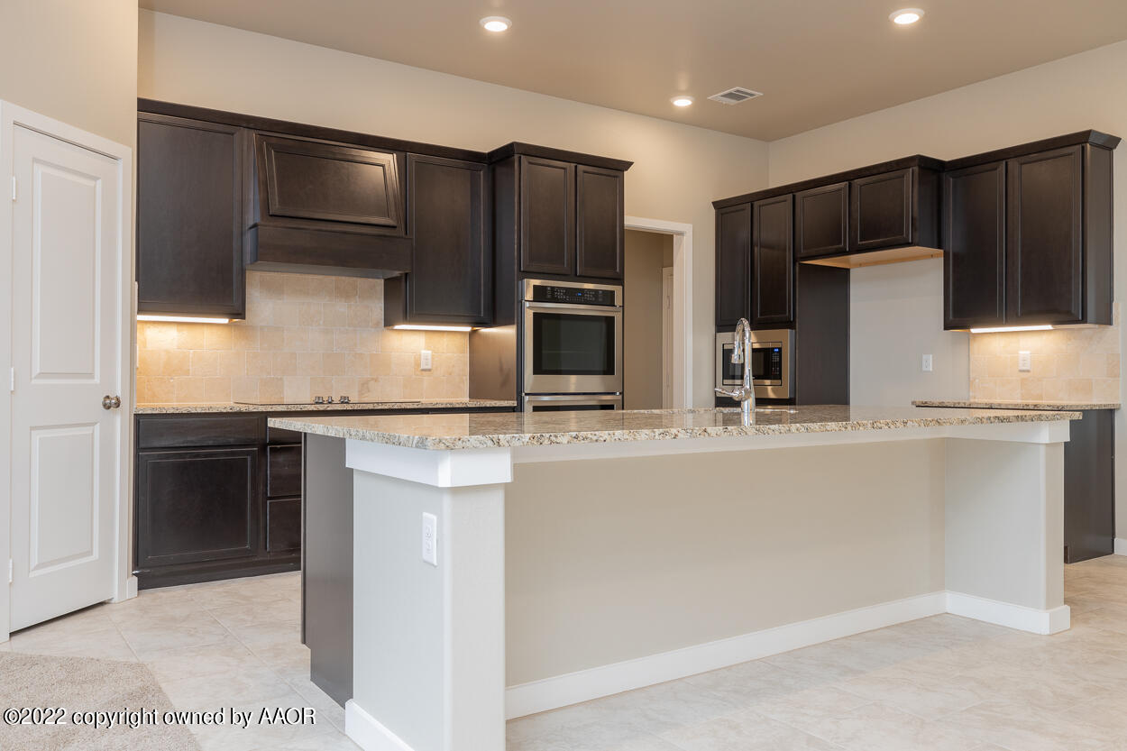 2600 Daybreak Lane Amarillo, TX 79124 - Photo 6 of 36 a kitchen with stainless steel appliances kitchen island granite countertop a refrigerator and a stove top oven