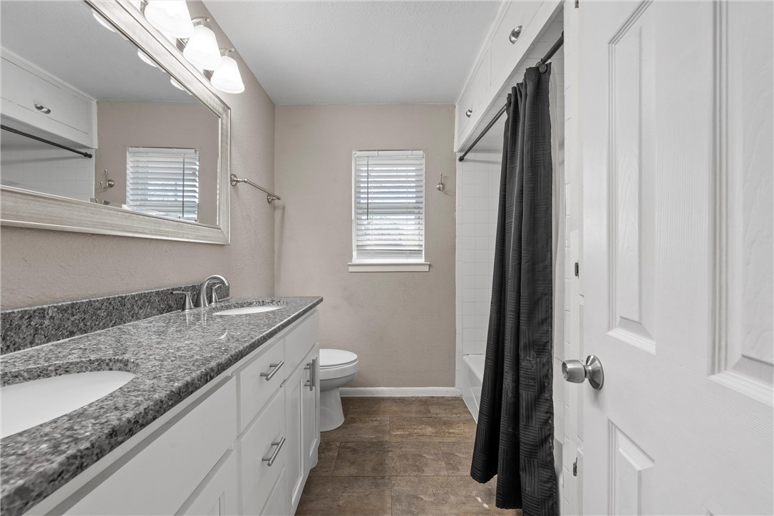 942 Longfellow Drive Waco, TX 76710 - Photo 21 of 38 a bathroom with a granite countertop sink and a mirror
