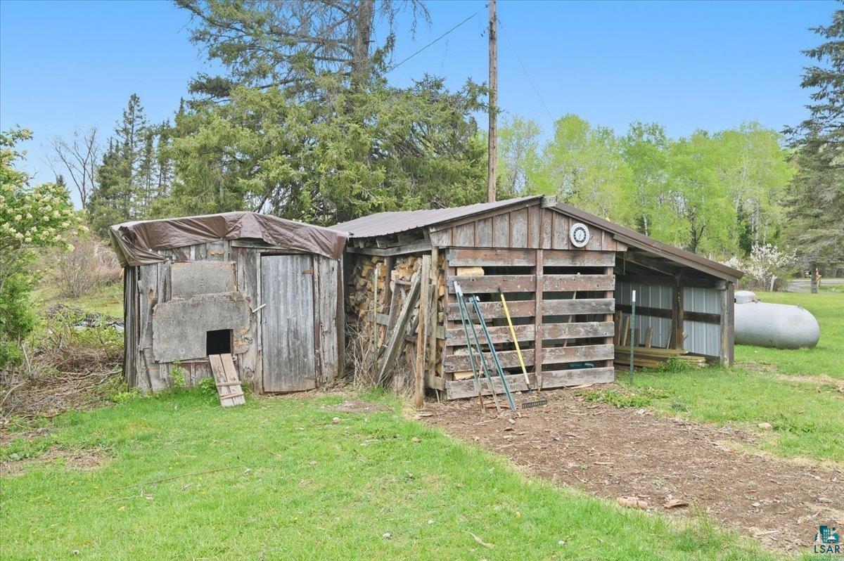 5190 County Road M Gordon, WI 54838 - Photo 5 of 31 Rustic outbuildings featuring a wood-sided shed with a tarp roof and a slatted wood shed with an attached lean-to