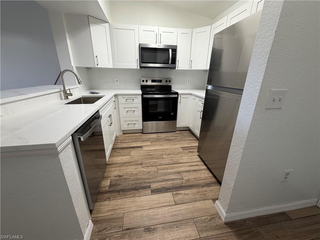 a kitchen with white cabinets and stainless steel appliances
