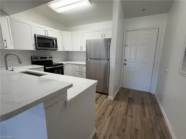 a kitchen with a refrigerator stove top oven and sink