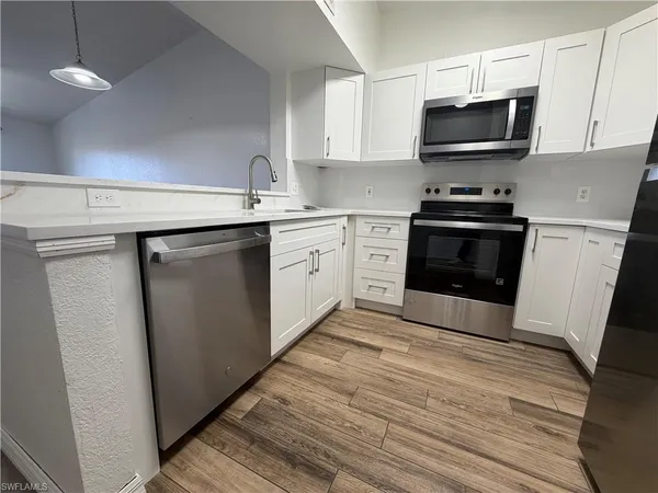 a kitchen with stainless steel appliances a stove microwave and sink