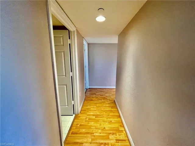 a view of a hallway with wooden floor