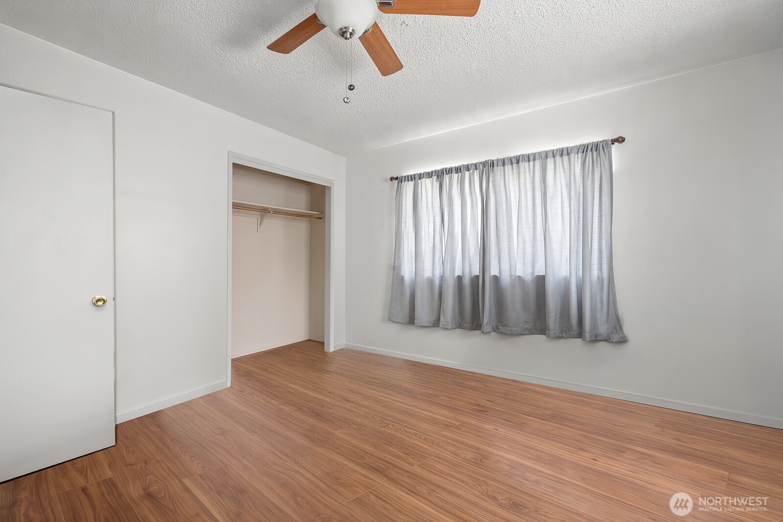 700 Harding Road Aberdeen, WA 98520 - Photo 13 of 21 an empty room with wooden floor fan and windows