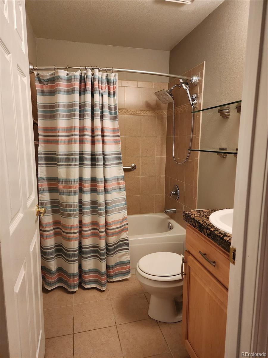 8601 East Dry Creek Road, Unit 112 Centennial, CO 80112 - Photo 17 of 19 a bathroom with a sink toilet and shower