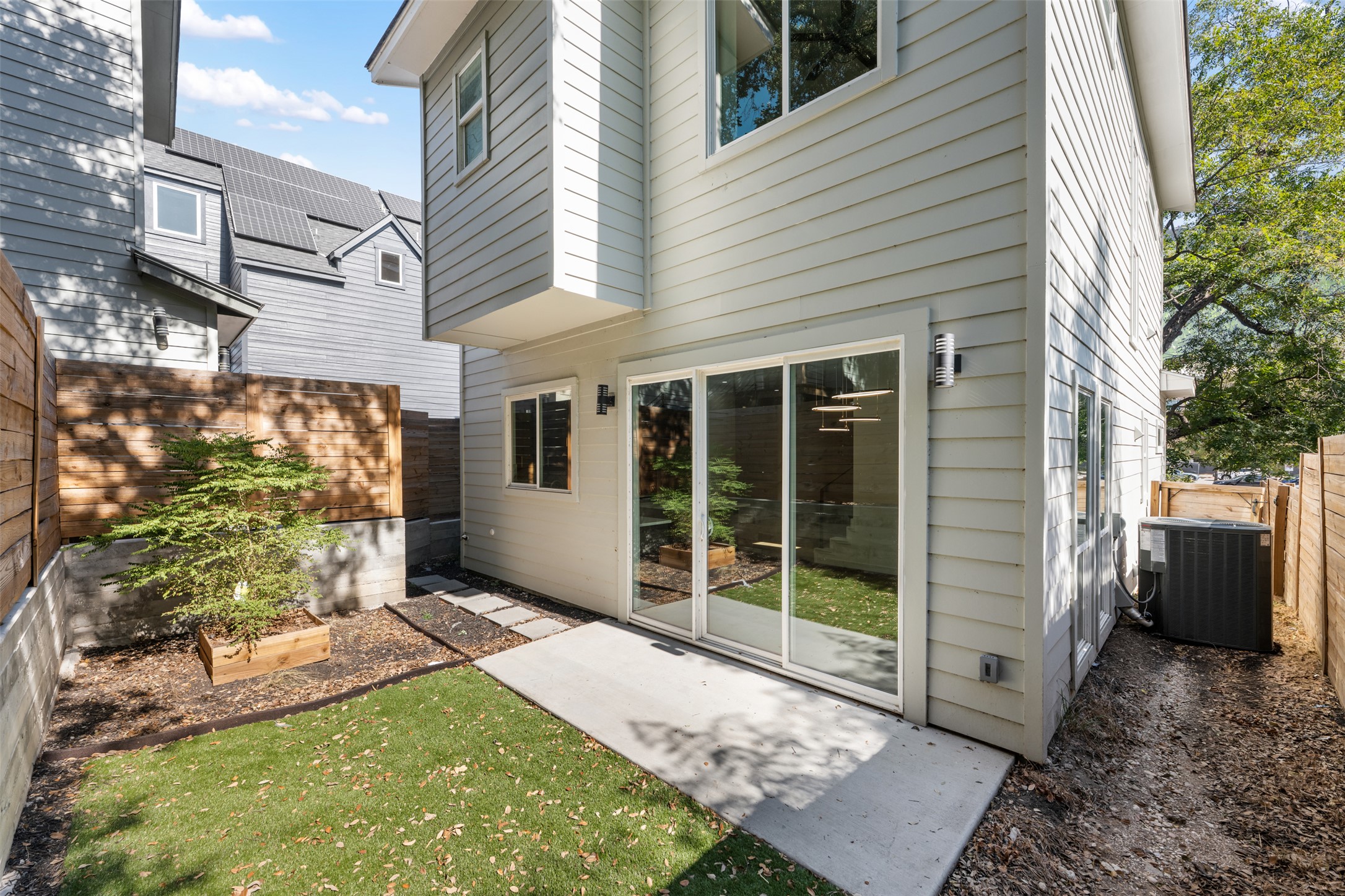 3010 Webberville Road, Unit 1 Austin, TX 78702 - Photo 11 of 38 Rear exterior featuring light-colored horizontal siding, a ground-level concrete patio, and sliding glass doors