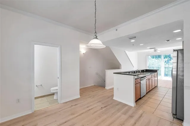 a kitchen with stainless steel appliances granite countertop a stove a sink and a wooden floor