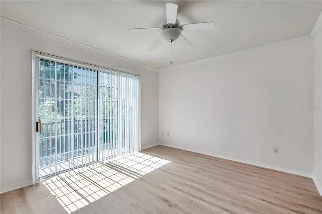 a view of wooden floor and a chandelier fan in a room