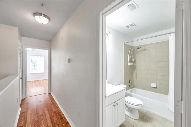 a bathroom with a granite countertop toilet a sink and a large mirror