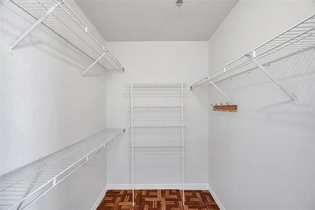a view of walk in closet with empty racks