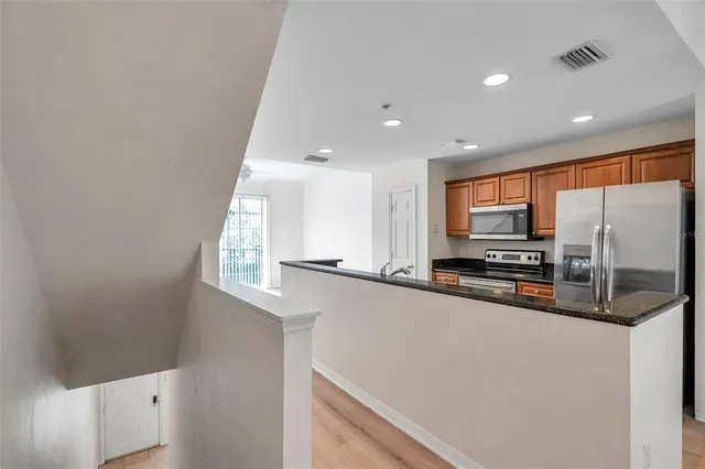 a kitchen with stainless steel appliances a microwave a sink and a refrigerator