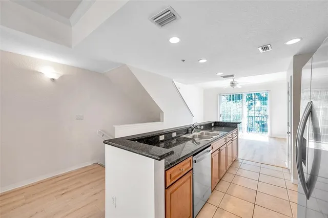a kitchen that has a sink a stove and a refrigerator