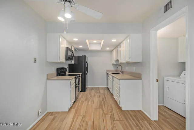 a kitchen with a sink a refrigerator and cabinets